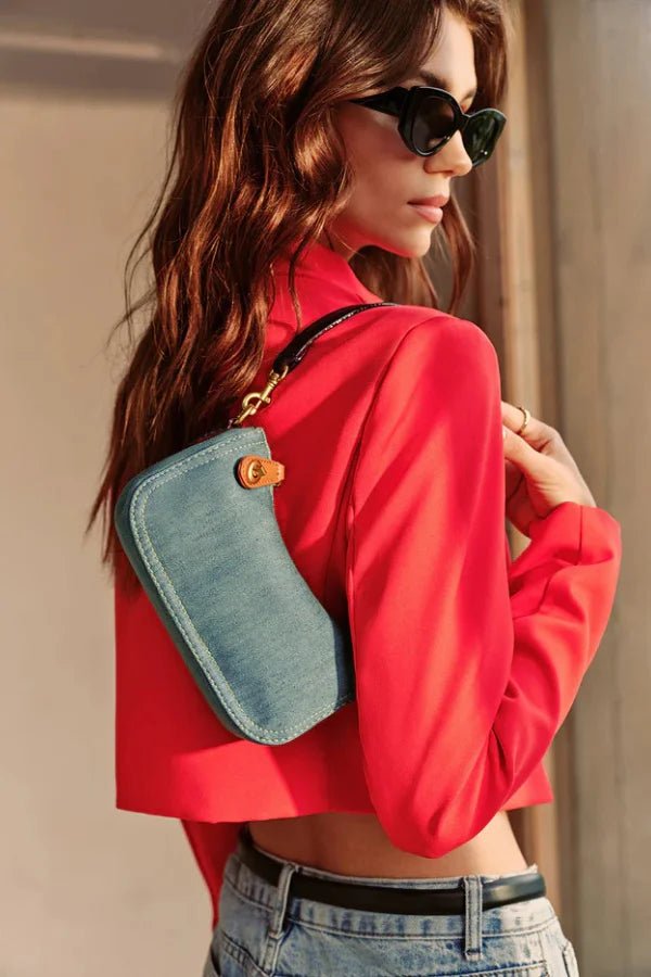 Close-up detail of the gold turn-lock clasp and contrast stitching on the Kouvr Romy denim bag.