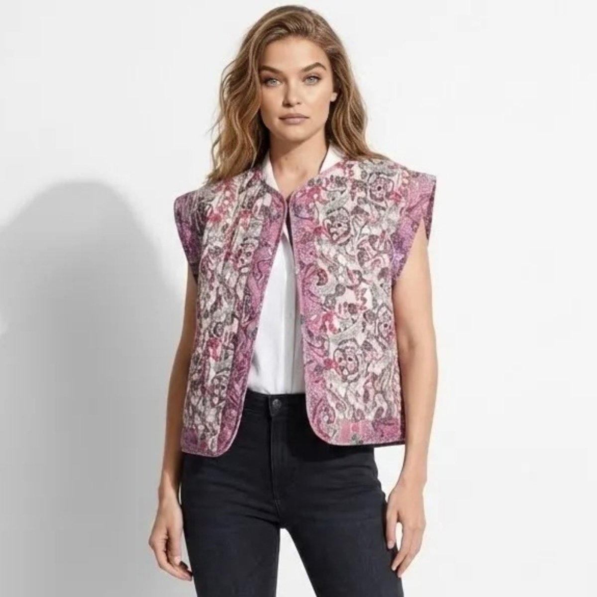 Model wearing the Kouvr Fashion Rose quilted floral paisley vest in pink and mauve, styled open over a white collared shirt and black denim jeans.