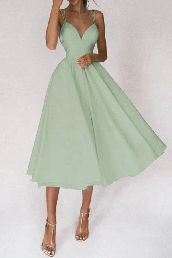 Model from behind showing the crisscross spaghetti straps on the Kouvr sage green A-line dress