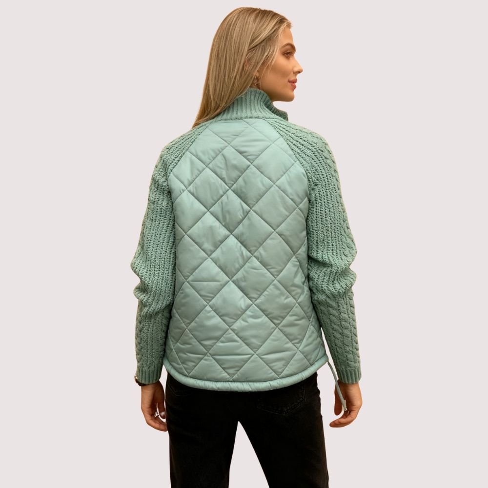 Model wearing Kouvr sage green quilted jacket with cable knit sleeves, viewed from the front