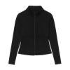 Woman wearing the black Kouvr Sculpting Athletic Jacket in a modern fitness studio.