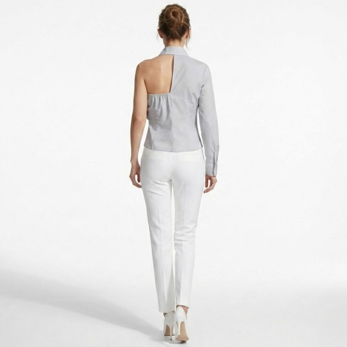 Back view of the Kouvr one-sleeve light grey shirt, highlighting the unique asymmetrical cutout detail below the collar.