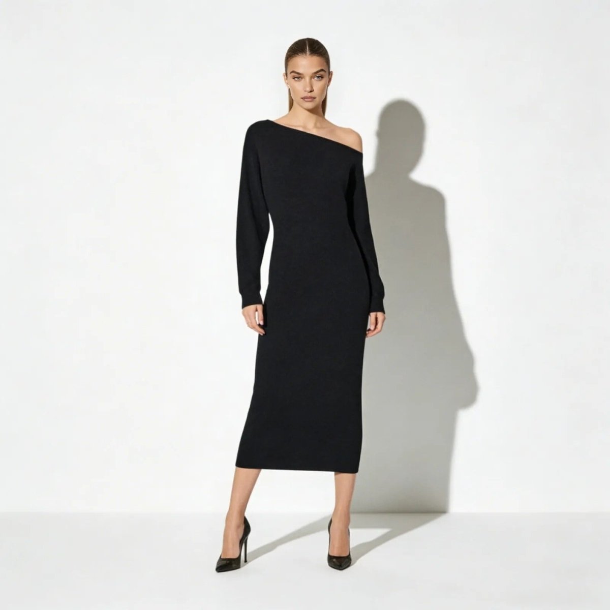 Model wearing the Kouvr Selena one-shoulder black knit midi dress with long sleeves, front view.
