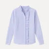 Woman wearing the Kouvr Shandee blue long sleeve ruffle blouse tucked into light wash jean