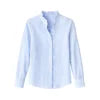 Woman wearing the Kouvr Shandee blue long sleeve ruffle blouse tucked into light wash jean