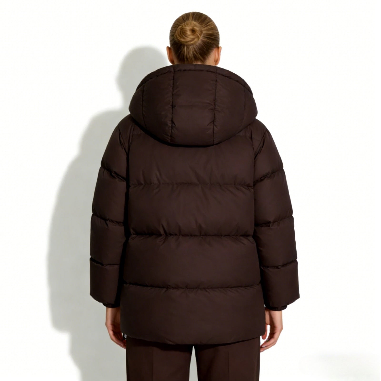 Back view of the Kouvr Sheena insulated winter coat in dark brown, highlighting the oversized hood and clean silhouette.
