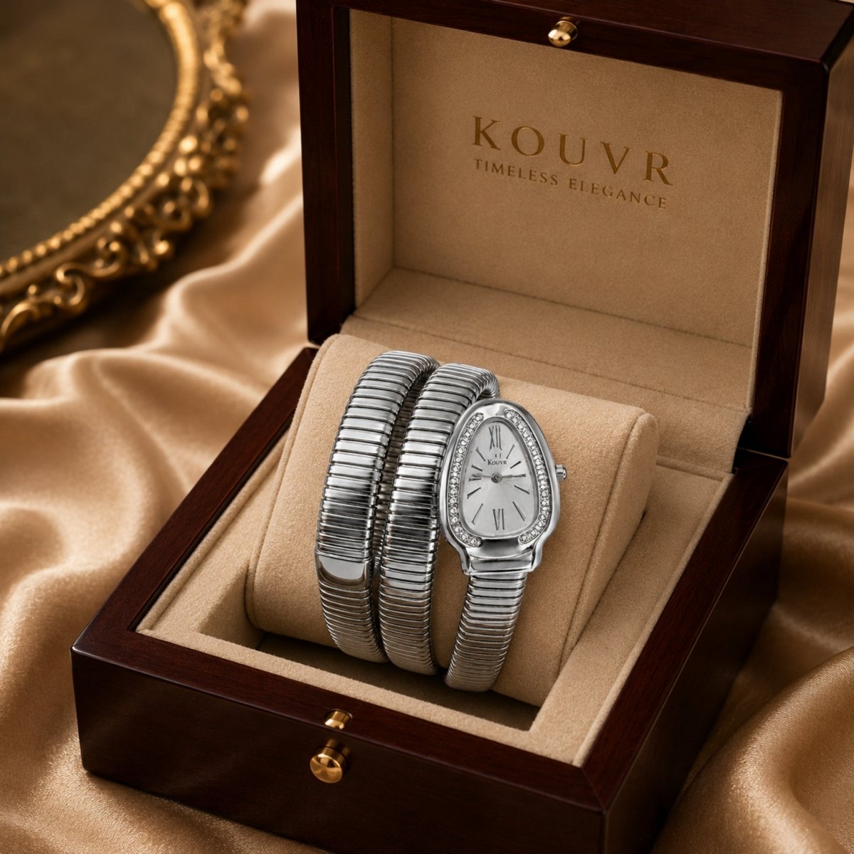 Silver Kouvr tubogas style wrap watch perfectly presented on a velvet cushion inside a classic wooden jewelry box with gold hardware.