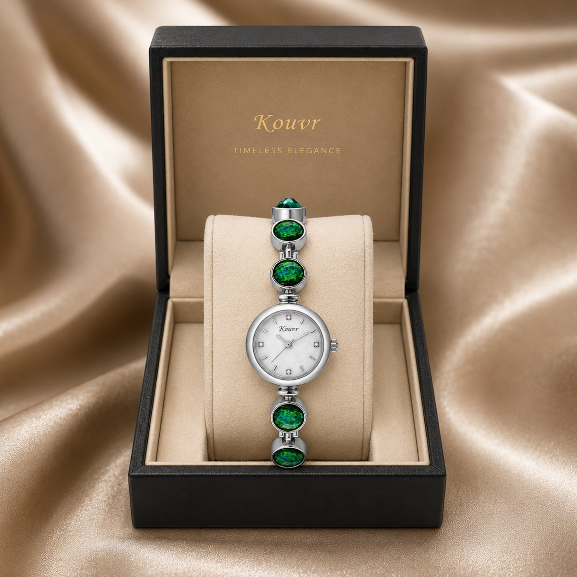Kouvr silver vintage style women's watch with green stones displayed perfectly inside a luxury black and cream presentation box on silk.