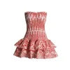 Model wearing the Kouvr red strapless mini dress with a smocked bodice and tiered ruffle skirt