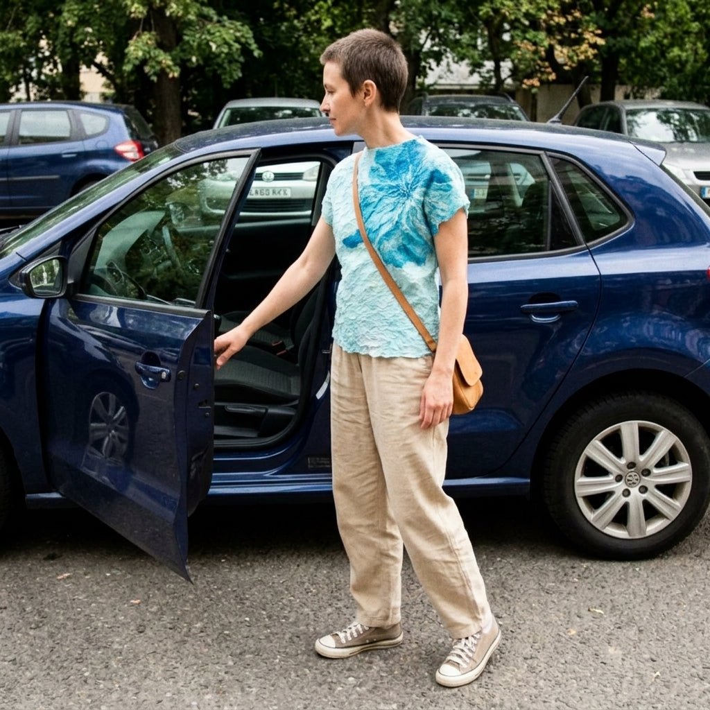 Woman stepping out of a car wearing a  blue textured flower statement blouse paired with casual wide leg beige trousers for everyday street style