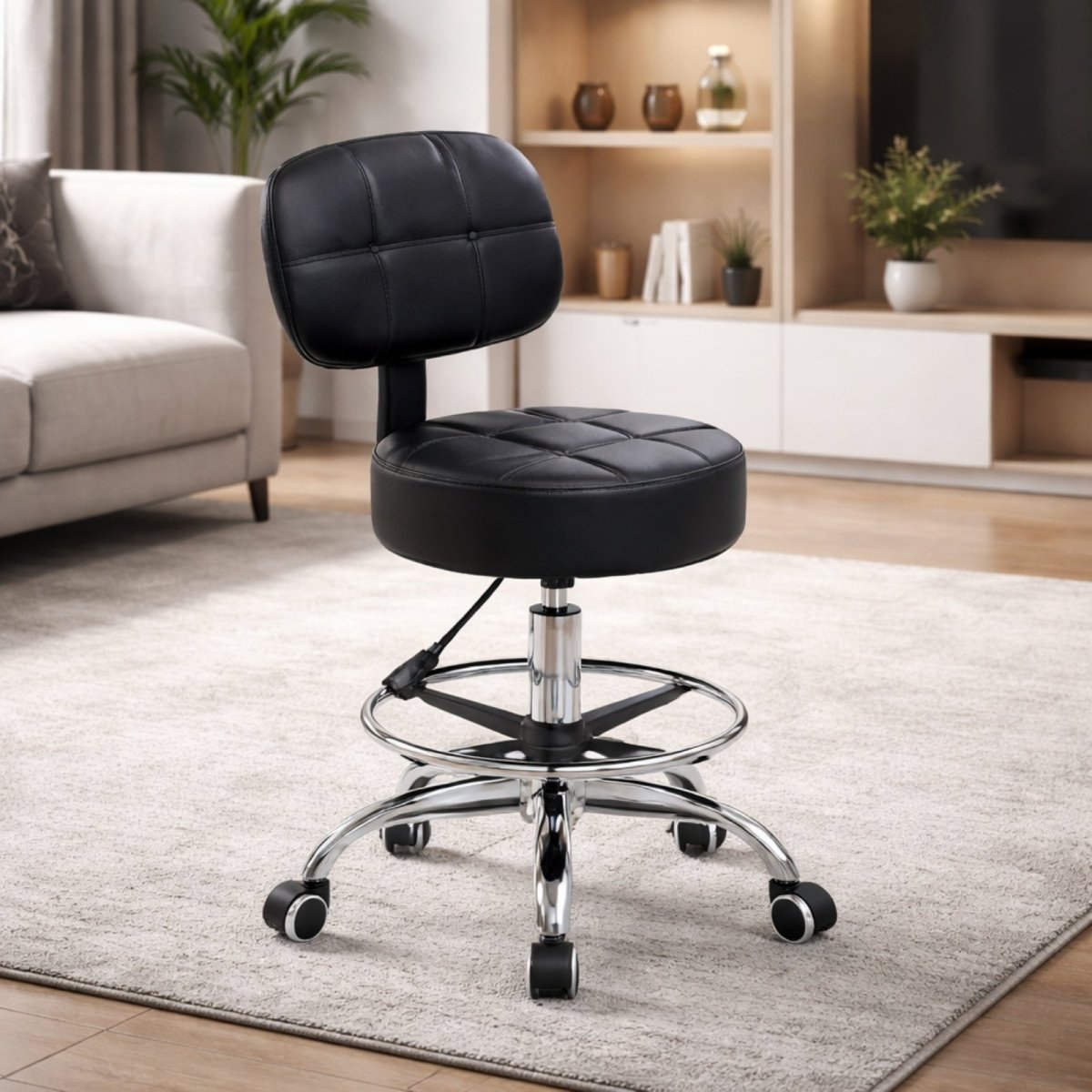 The Kouvr adjustable task stool in black tufted leather, shown in a brightly lit, modern living room setting on a beige rug.