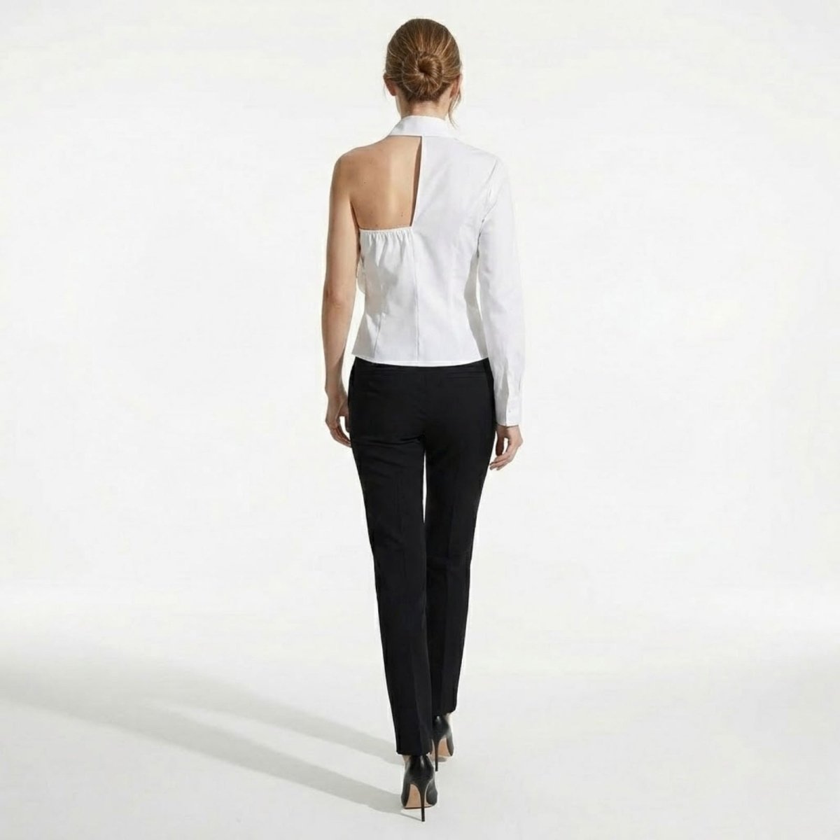 Back view of the Kouvr Teresa one-shoulder white shirt, highlighting the asymmetrical cutout and tailored fit.