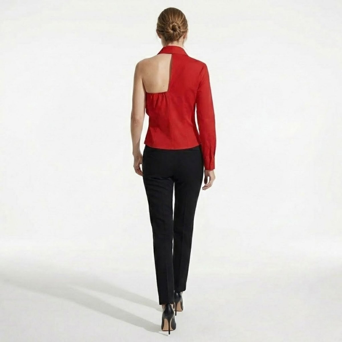 Model from the back showing the asymmetrical cutout detail of the Kouvr red one-shoulder collared blouse.
