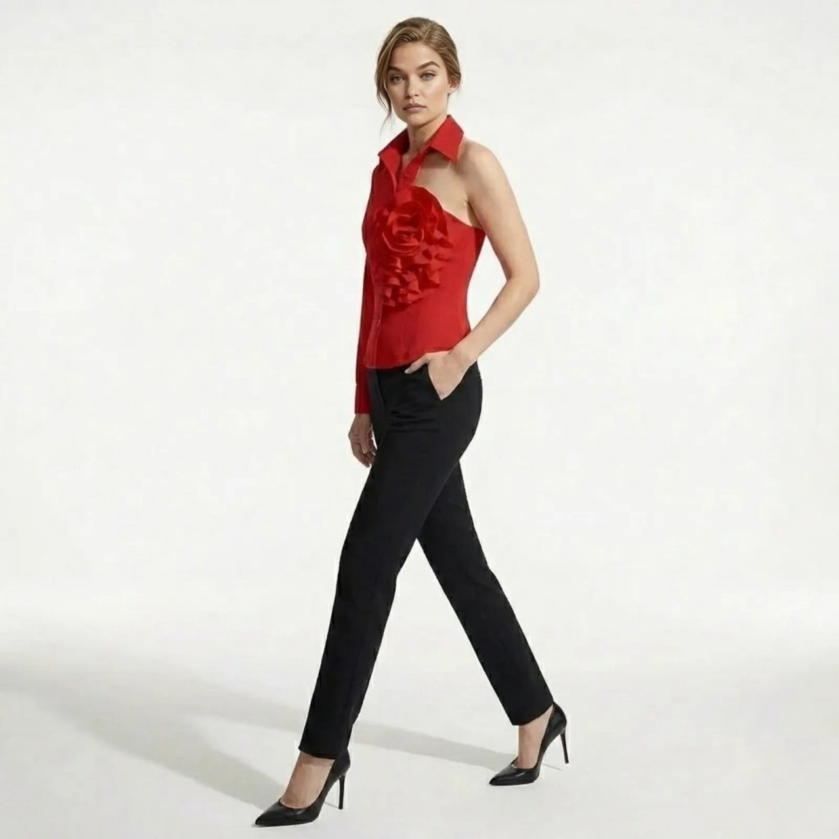 Model in a side profile walking pose wearing the Kouvr red asymmetrical blouse, showing the single long sleeve and fitted silhouette.