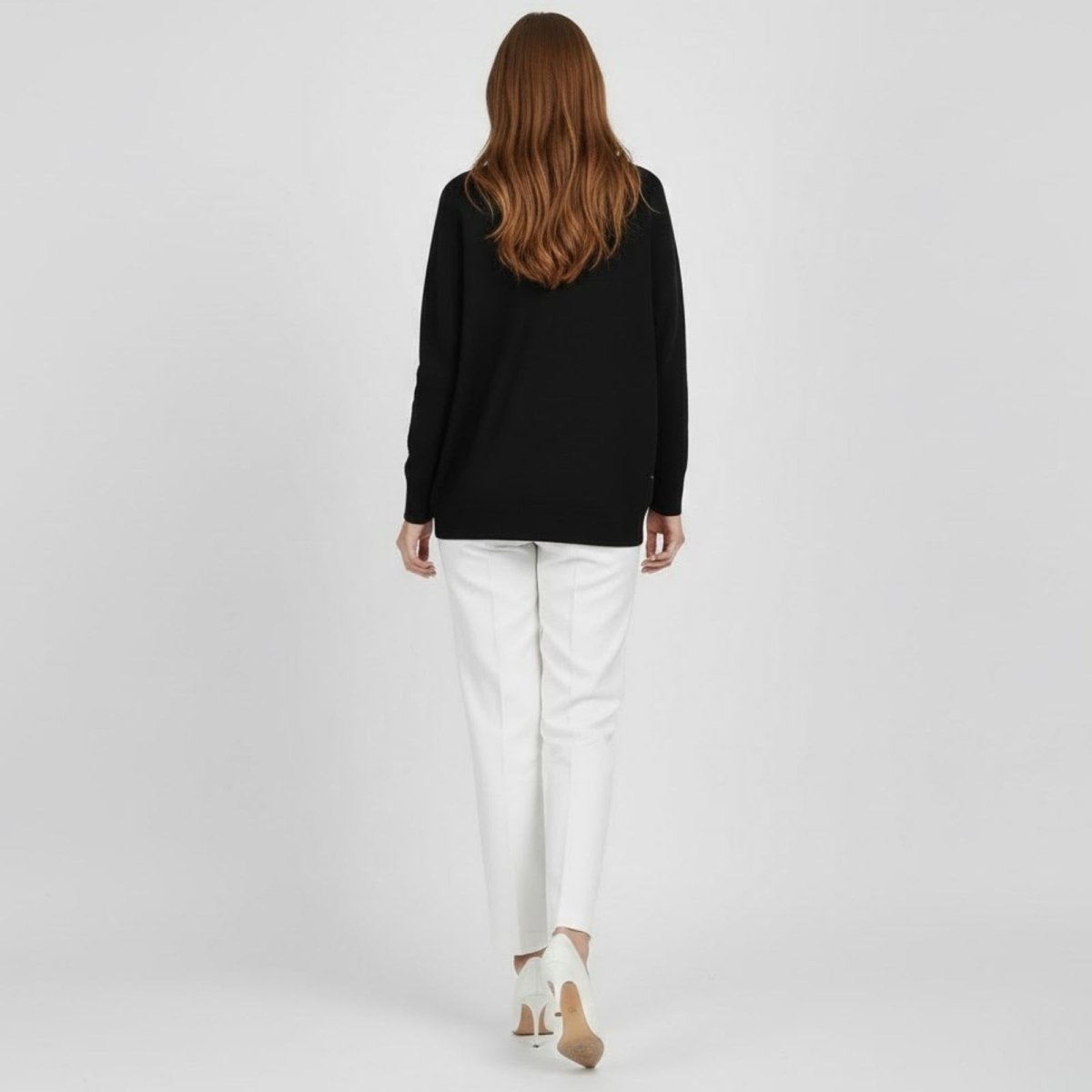 Back view of a woman wearing the minimalist black Kouvr Fashion Tina knit pullover.