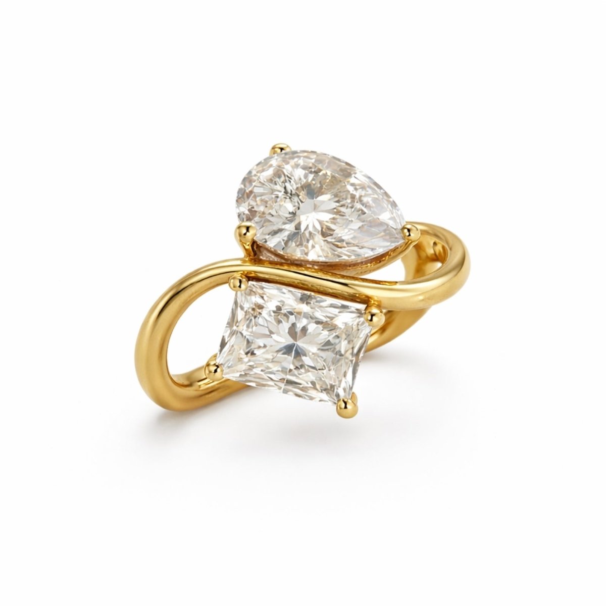 The Kouvr Toi et Moi diamond ring in 18k yellow gold with a pear cut and princess cut diamond on a white background.