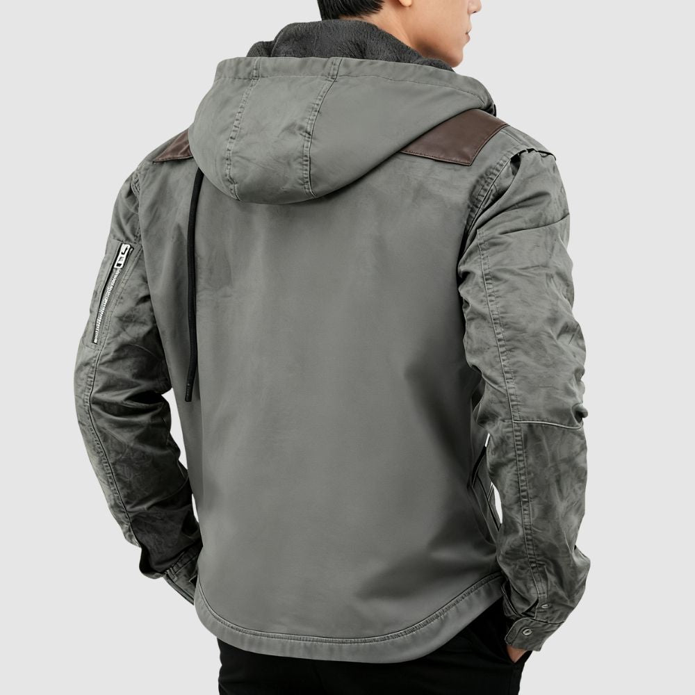 Man wearing the Kouvr tyrian sherpa-lined gray canvas hooded jacket, facing back with hands in pockets.
