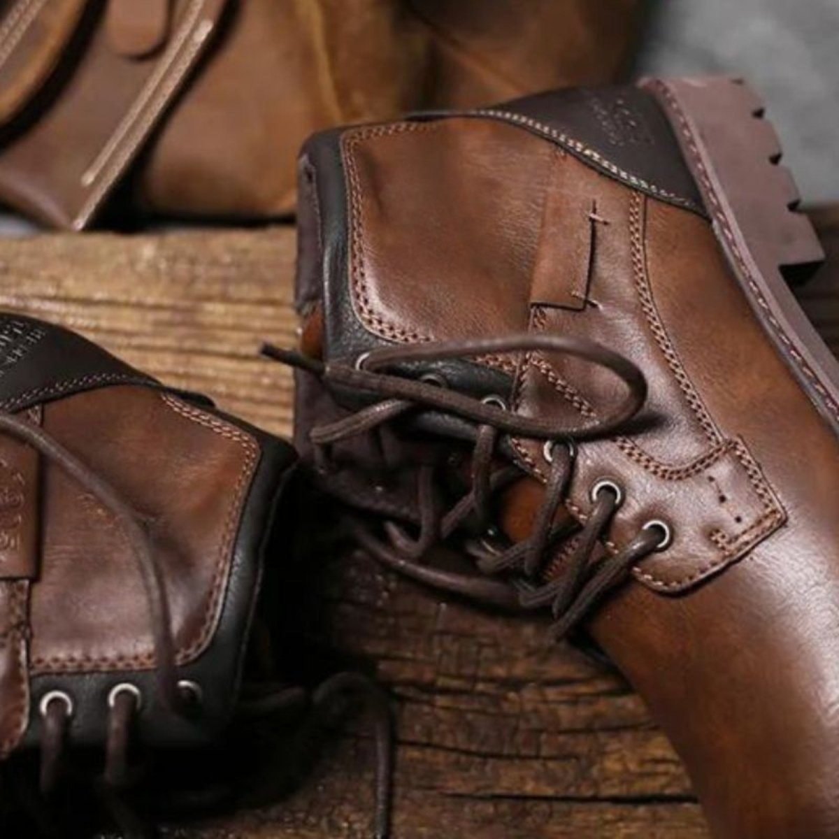 Close-up of brown leather boots on a wooden surface