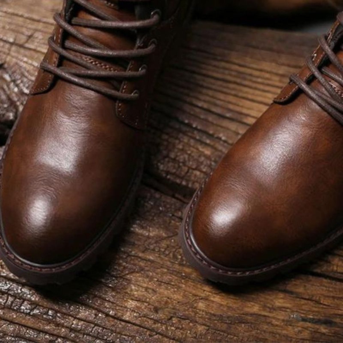 Pair of brown leather boots on a wooden surface