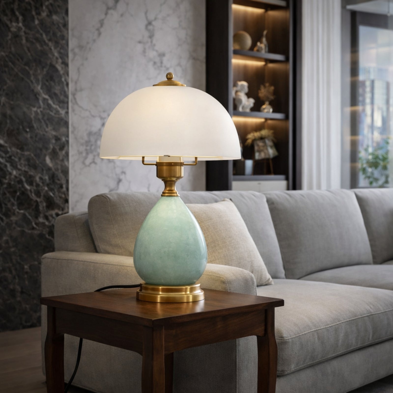 Mid-century modern style ceramic lamp with warm light placed on a wooden side table next to a grey sofa.