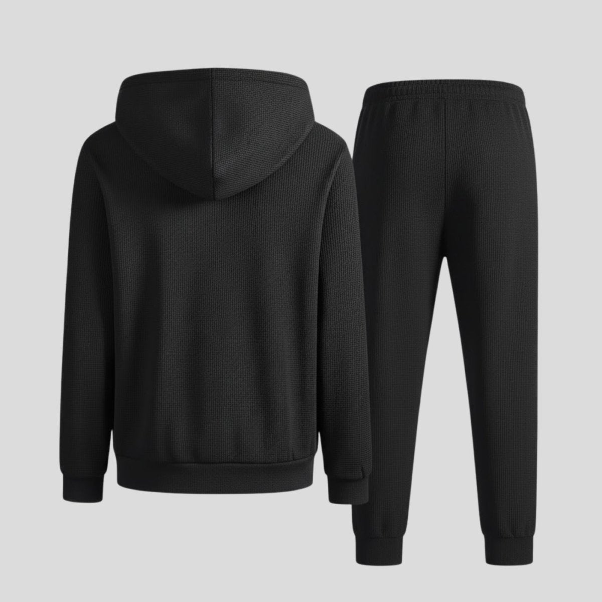 Flat lay showing the back of the Kouvr men's waffle-knit hoodie and joggers in black, highlighting the texture and construction.