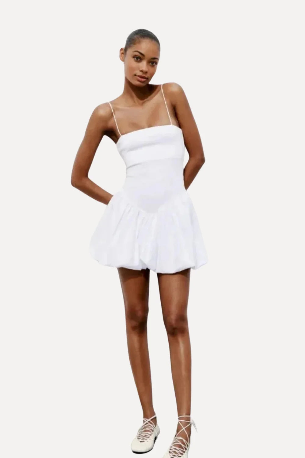 Model wearing the Kouvr white bubble hem mini dress with spaghetti straps