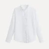 Model wearing the Kouvr women's white textured blouse with ruffle collar, paired with light wash jeans