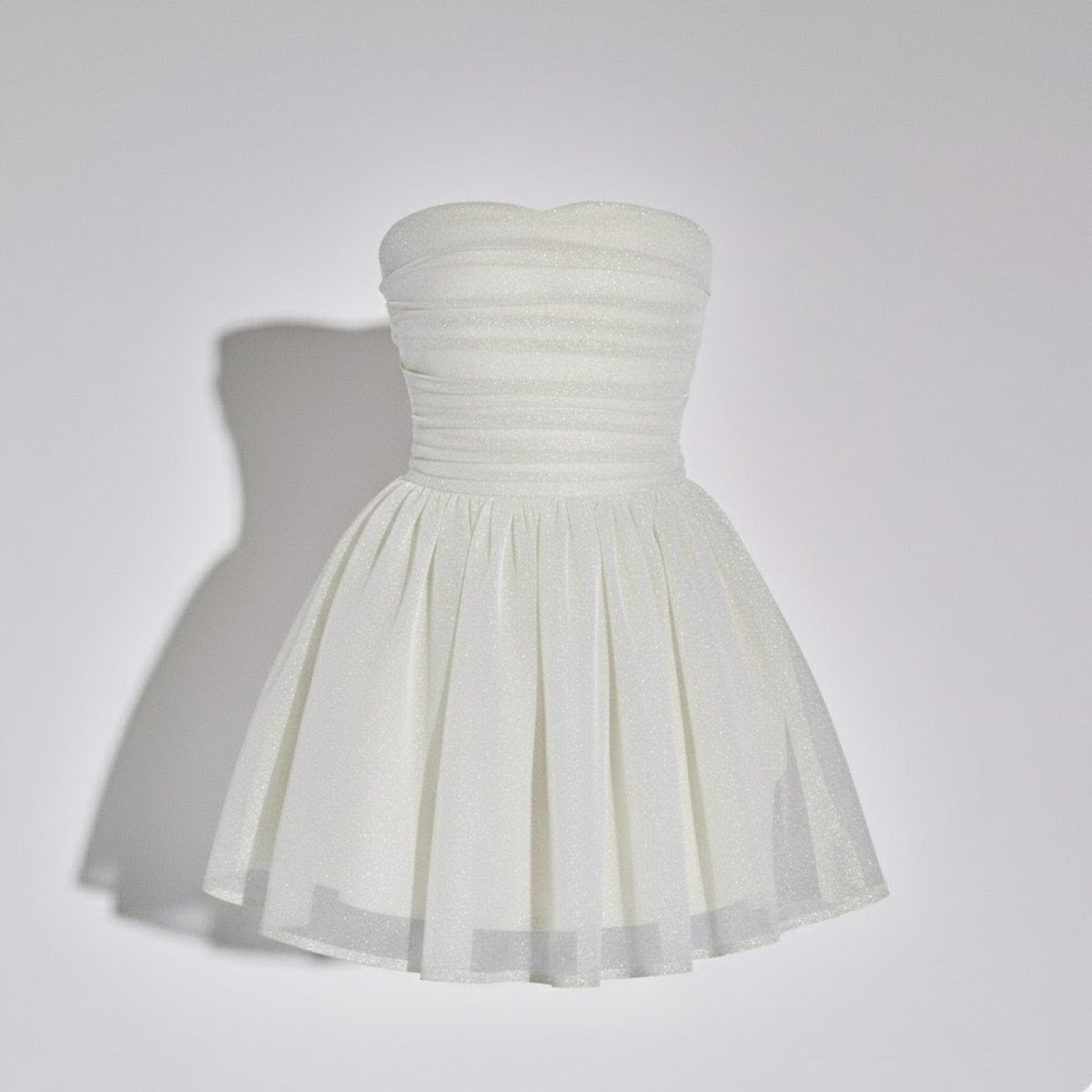 Product-only studio shot of a white strapless mini dress with a structured ruched sweetheart bodice and shimmering A-line tulle skirt.