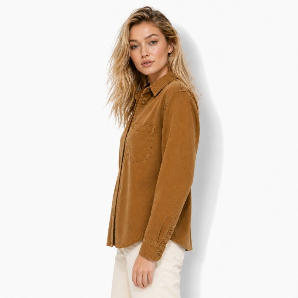 Side profile of the Kouvr relaxed fit brown corduroy blouse showing the elegant curved hemline and sleeve drape