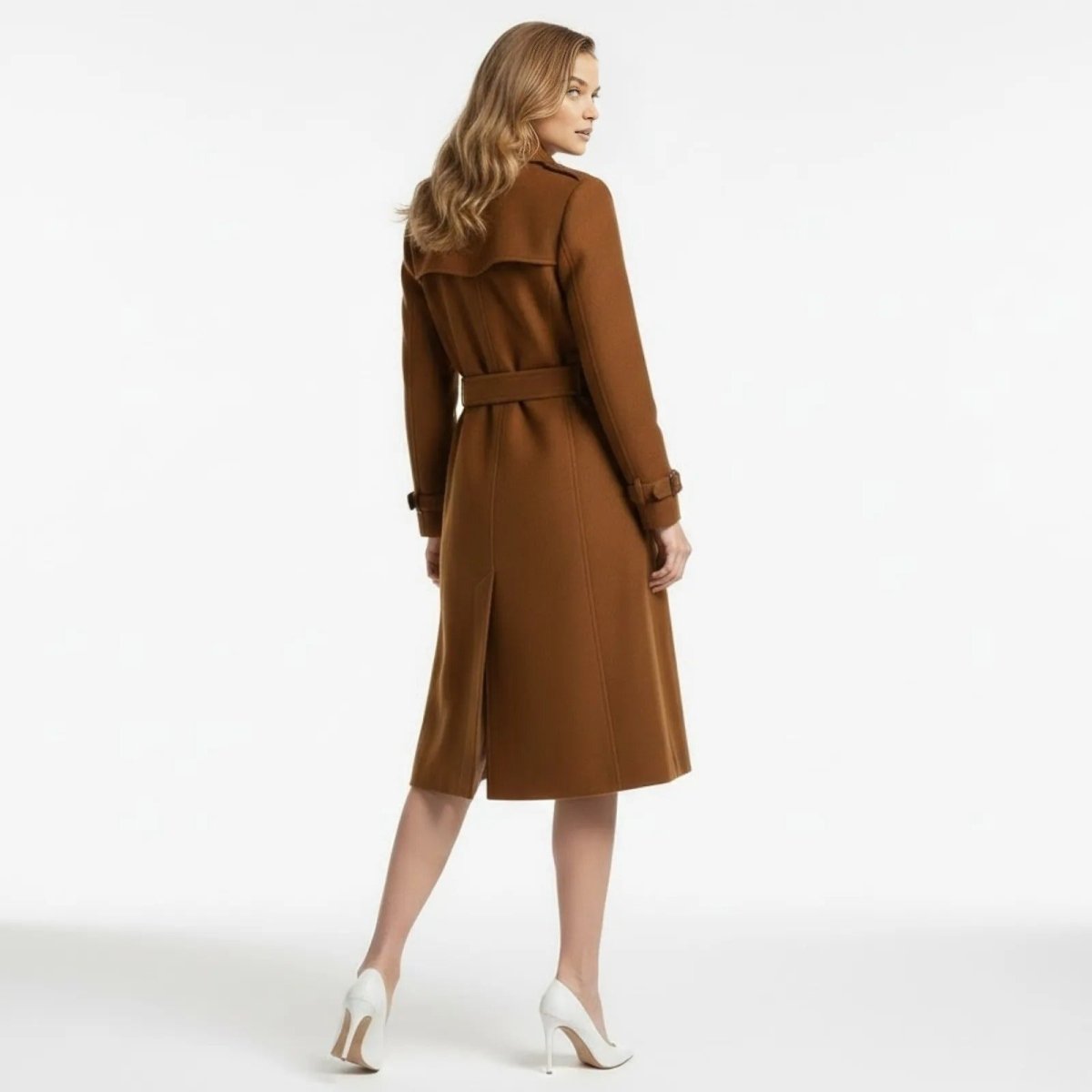 Back view of the Kouvr caramel wool trench coat, showcasing the belted waist, central vent, and signature storm flap detail.
