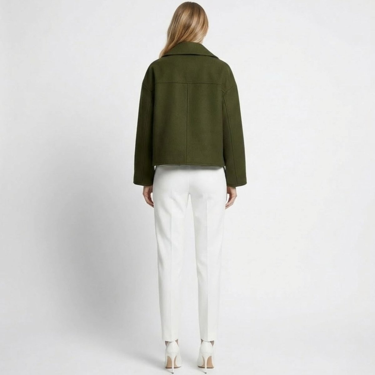 Back view of a model in the Kouvr dark green cropped wool peacoat, highlighting the clean seam details and wide collar.