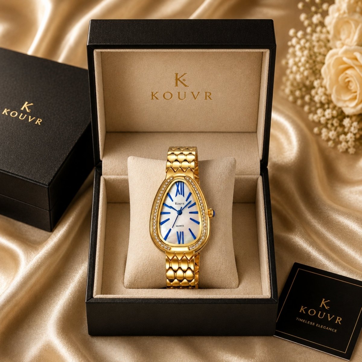 Emerging luxury brand Kouvr women's gold teardrop watch with mother of pearl dial and blue hands displayed inside a premium velvet-lined presentation box.