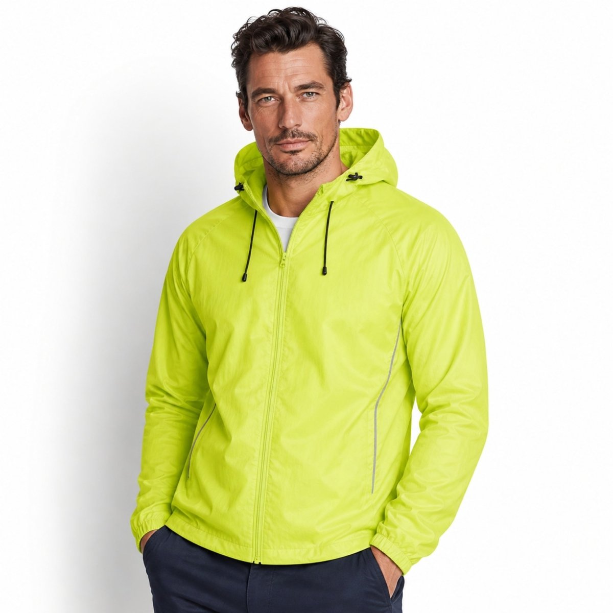Male model wearing Kouvr yellow lightweight hooded windbreaker jacket with front zipper and reflective details