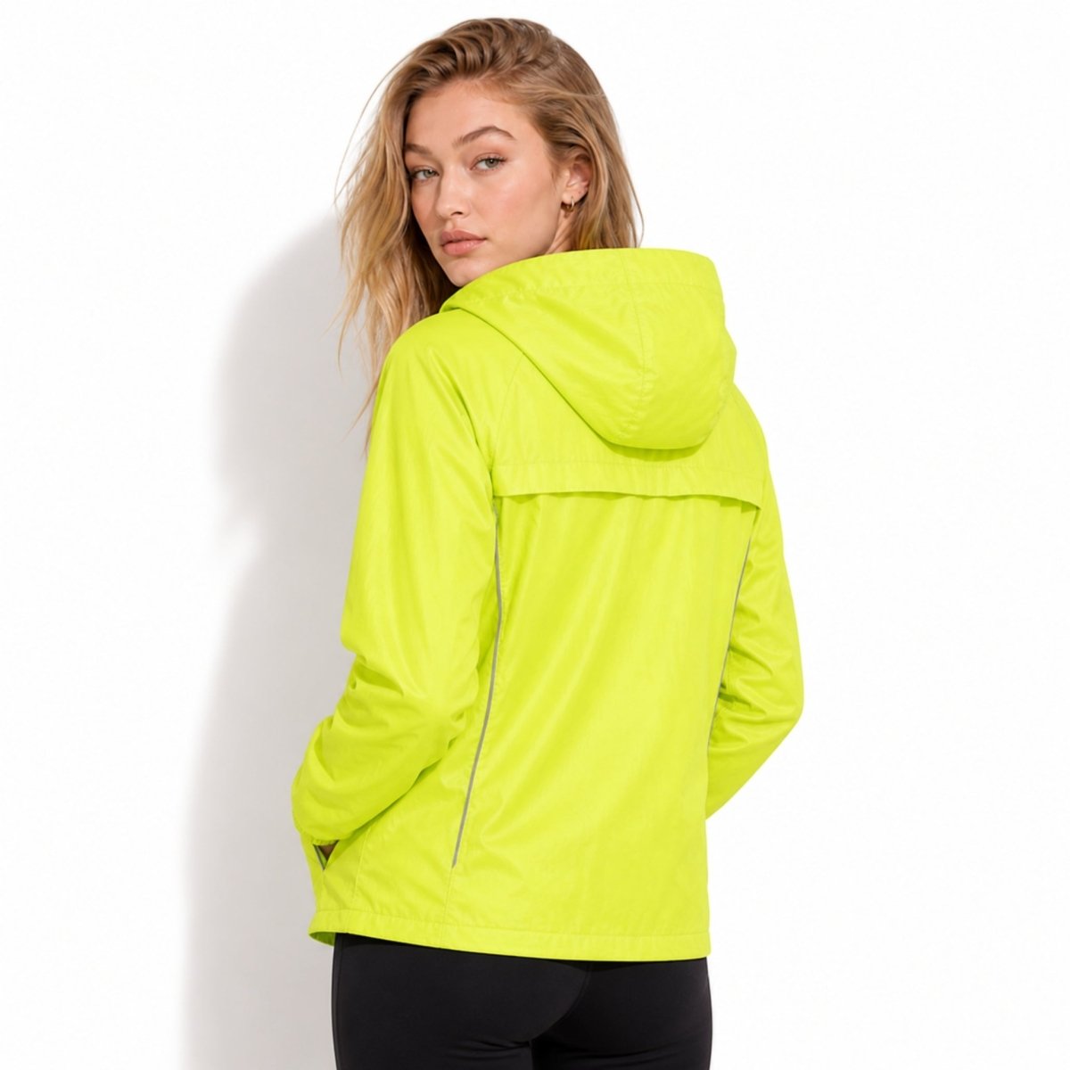 Back view of female model in Kouvr yellow windbreaker showing breathable horizontal back yoke ventilation panel