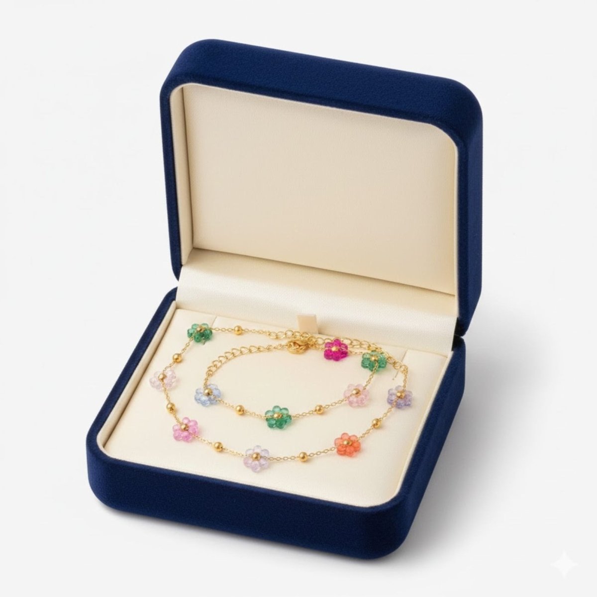 Ysabel multicolor beaded flower necklace and matching bracelet laid out on a clean white background, showing the 18k gold chain and lobster clasps in a blue jewelry box