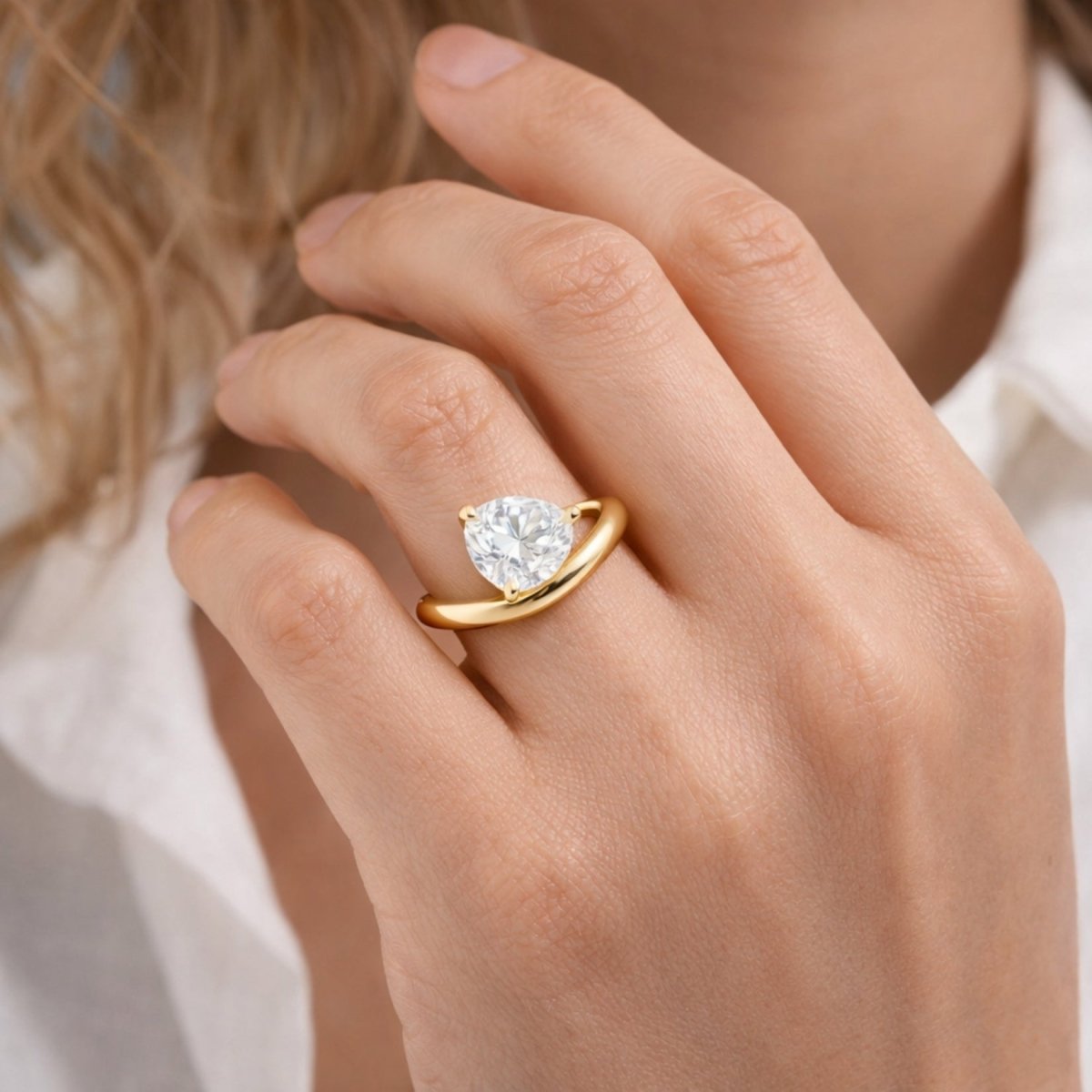 Top-down view of the Kouvr Zoella 2 carat heart diamond engagement ring on a woman's finger.