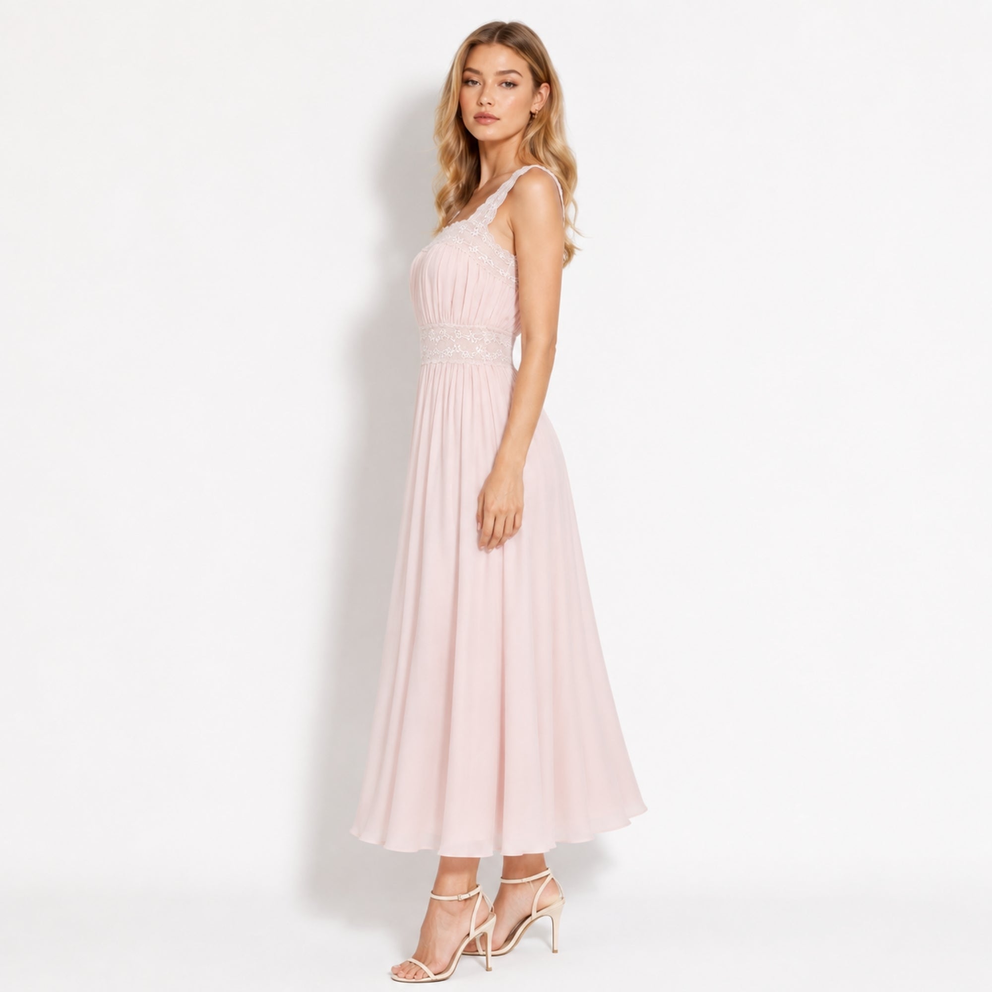 Side view of luxury light pink flowy midi dress showing pleated bodice and delicate lace waist