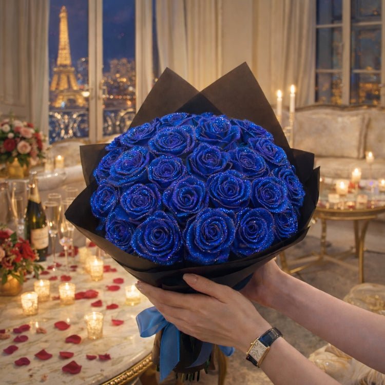 A close-up view of hands holding a luxurious bouquet of handmade royal blue glitter roses, tied with a blue satin ribbon in a romantic setting.
