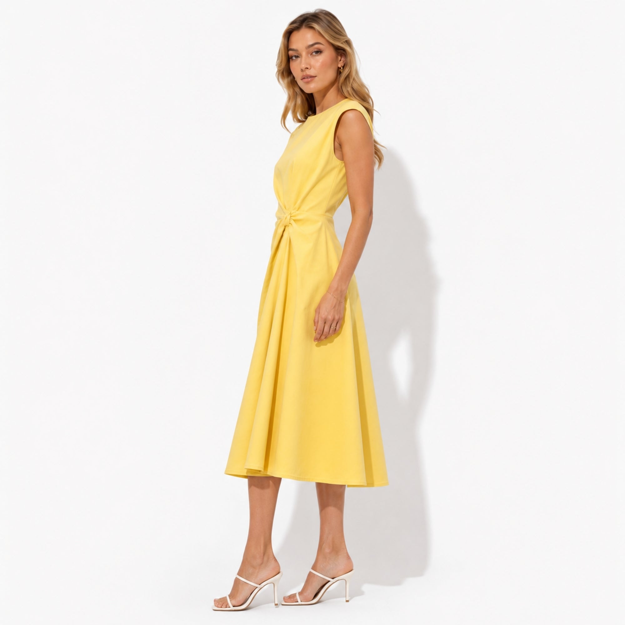 Side profile of luxury yellow A-line flared midi dress showing precision waist draping and structured sleeveless silhouette.