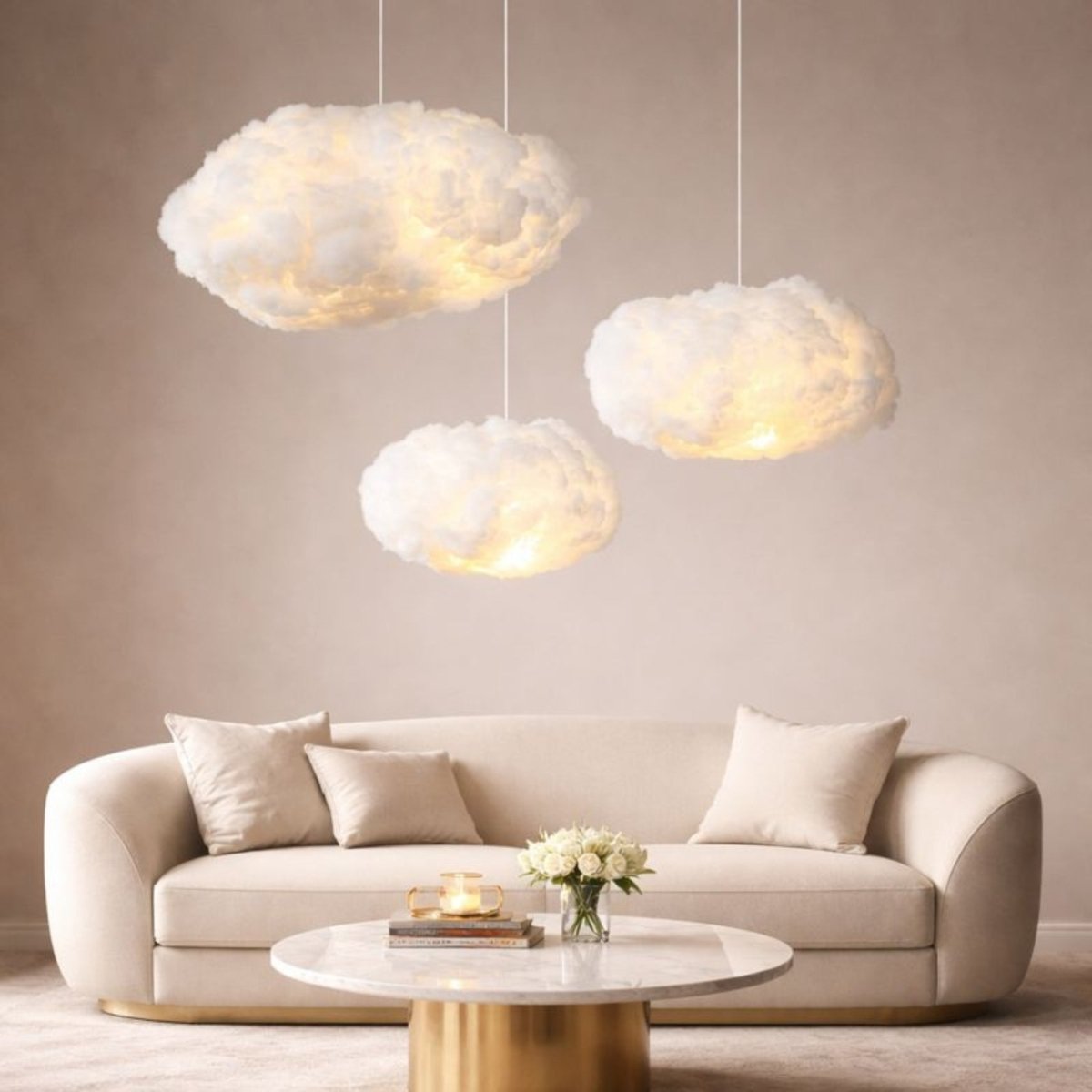 Trio of aesthetic cloud lights hanging in a bright, minimalist living room with a white curved sofa and gold accents.
