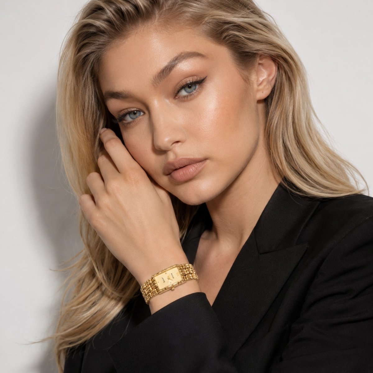 Fashion model wearing a vintage style women's gold link bracelet watch with a black blazer, showcasing the elegant rectangular timepiece.