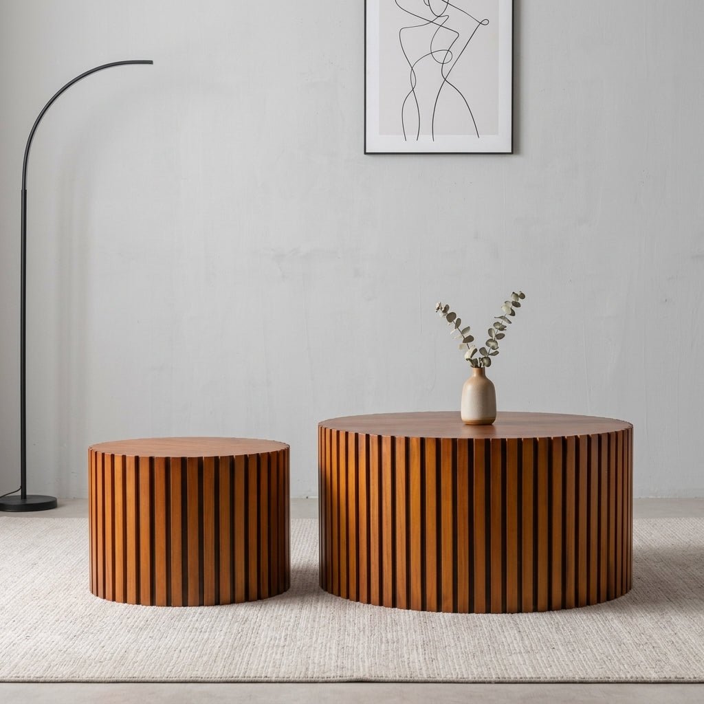 Two round ribbed walnut coffee tables displayed side by side in a minimalist Japandi inspired room setting with clean lines.