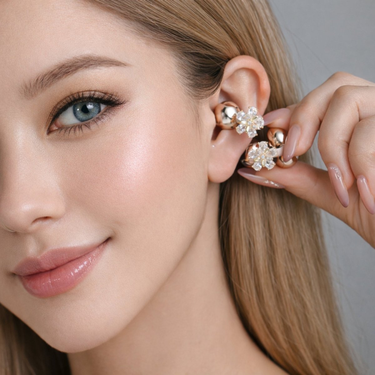 A close-up of a model wearing the Kouvr crystal flower Hollis earrings, demonstrating the comfortable clip-on fit.