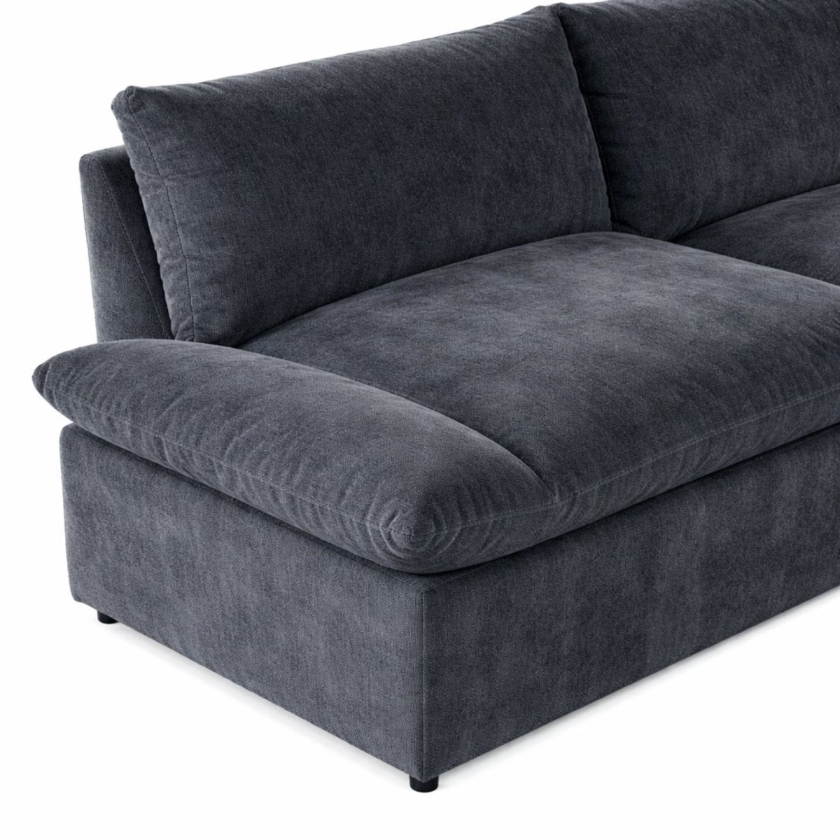 Modern dark grey cloud sectional styled in a living room with a round wood coffee table and rug