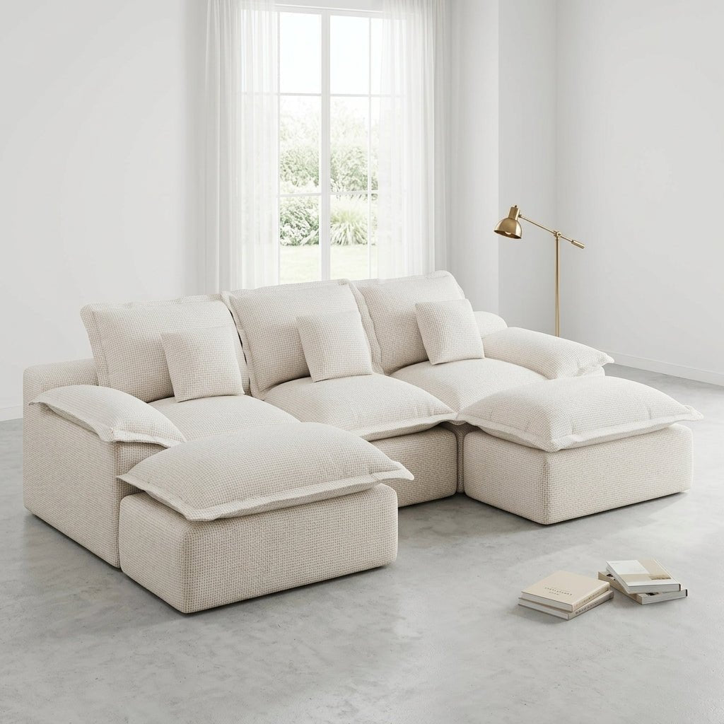 Modern cream-colored pit sectional sofa with gold floor lamp in a clean, minimalist studio setting.