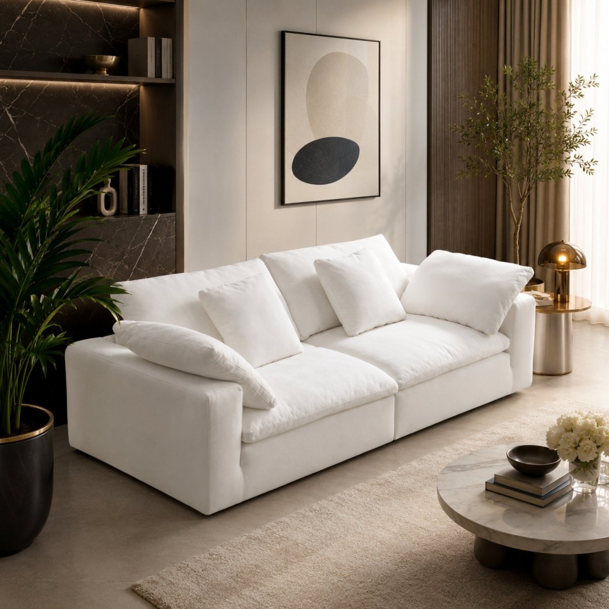 Elegant styling of the Kouvr white modular sofa with indoor plants and a marble coffee table.