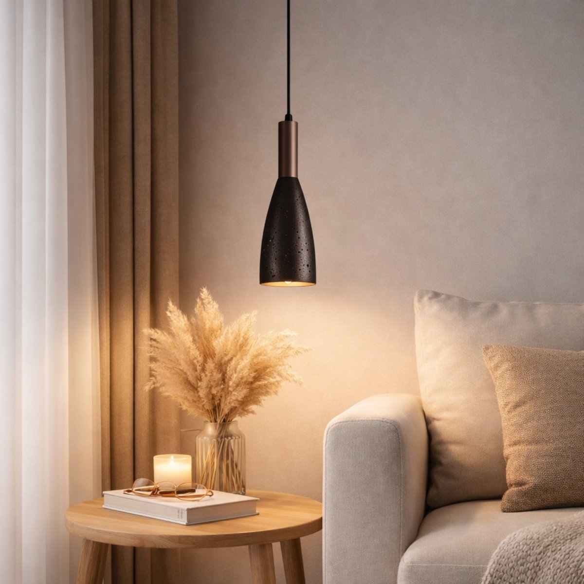 Warm glowing modern concrete and wood hanging pendant light illuminating a quiet reading corner and wooden side table next to a neutral sofa.