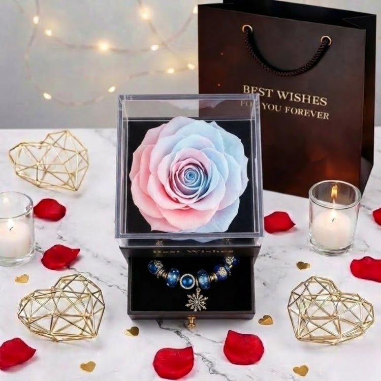 Overhead view of a soft pastel pink and blue gradient eternal rose centerpiece in a jewelry box, surrounded by gold geometric decor.