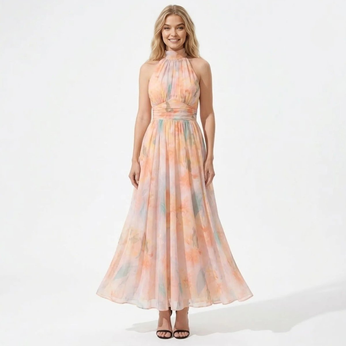 Front view of the Kouvr pastel watercolor floral halter maxi dress on a blonde model smiling.