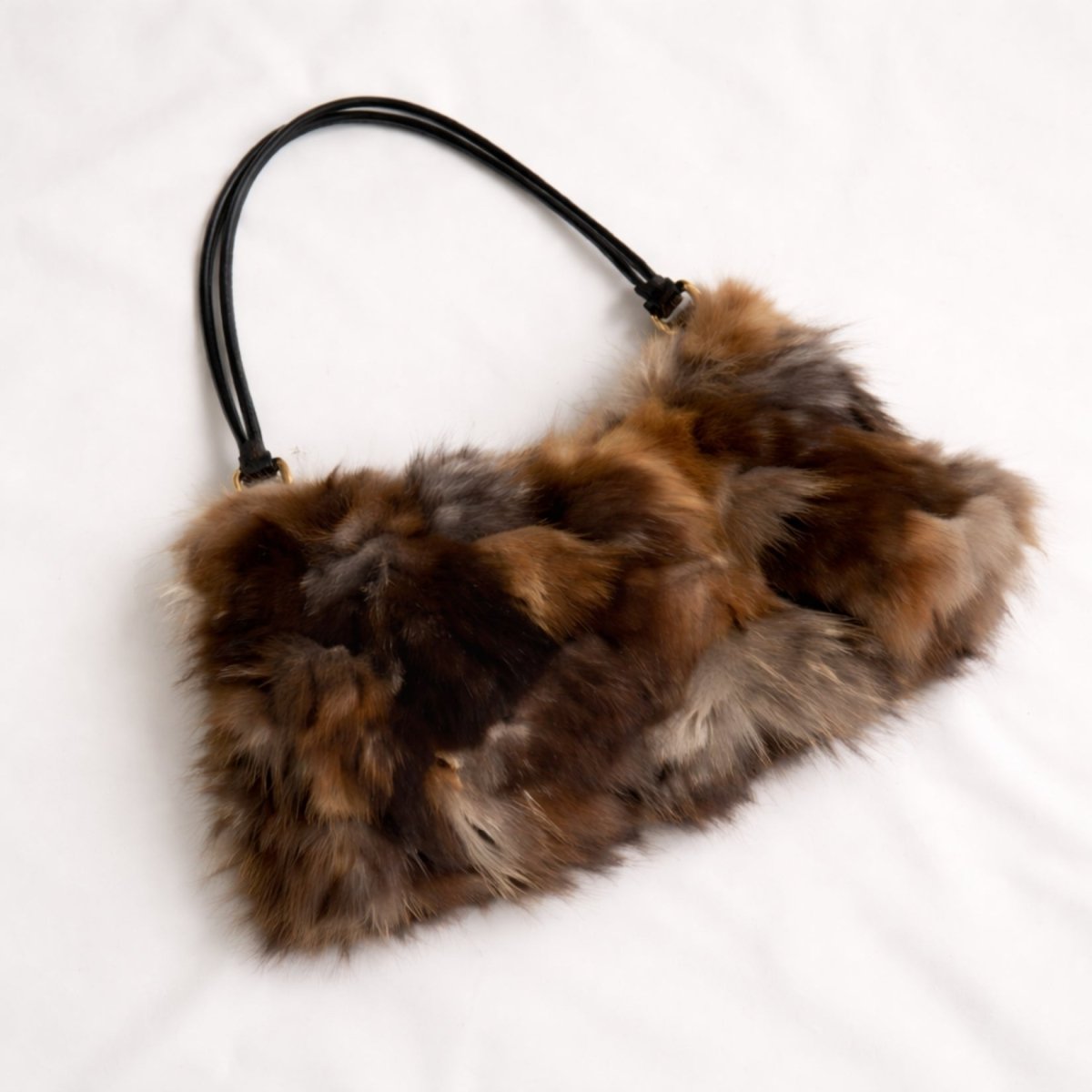 Top-down view of the Kouvr Carina fur handbag showcasing the natural brown, grey, and tan patchwork pattern and leather straps.